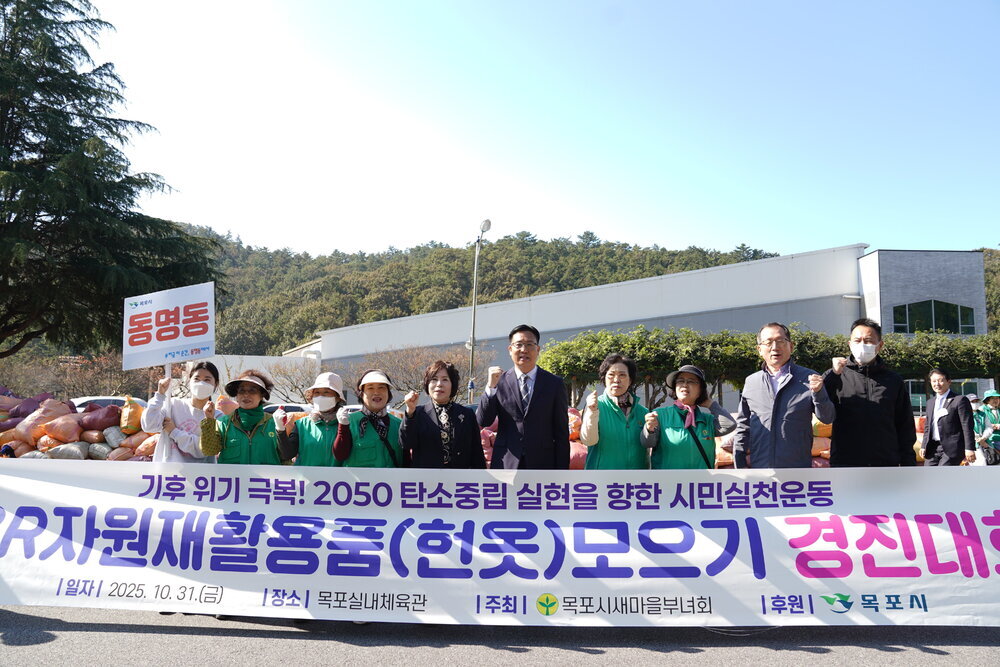 '동명동' 표지판을 든 시민들이 기후 위기 극복을 위한 헌옷 모으기 경진대회 현수막 앞에서 단체 사진을 촬영하는 모습.